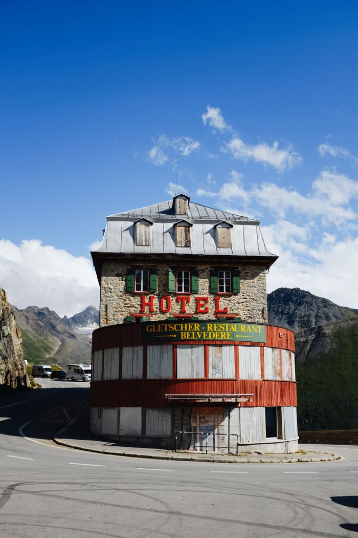 services-04 Charming hotel landmark by a winding mountain road with clear skies.