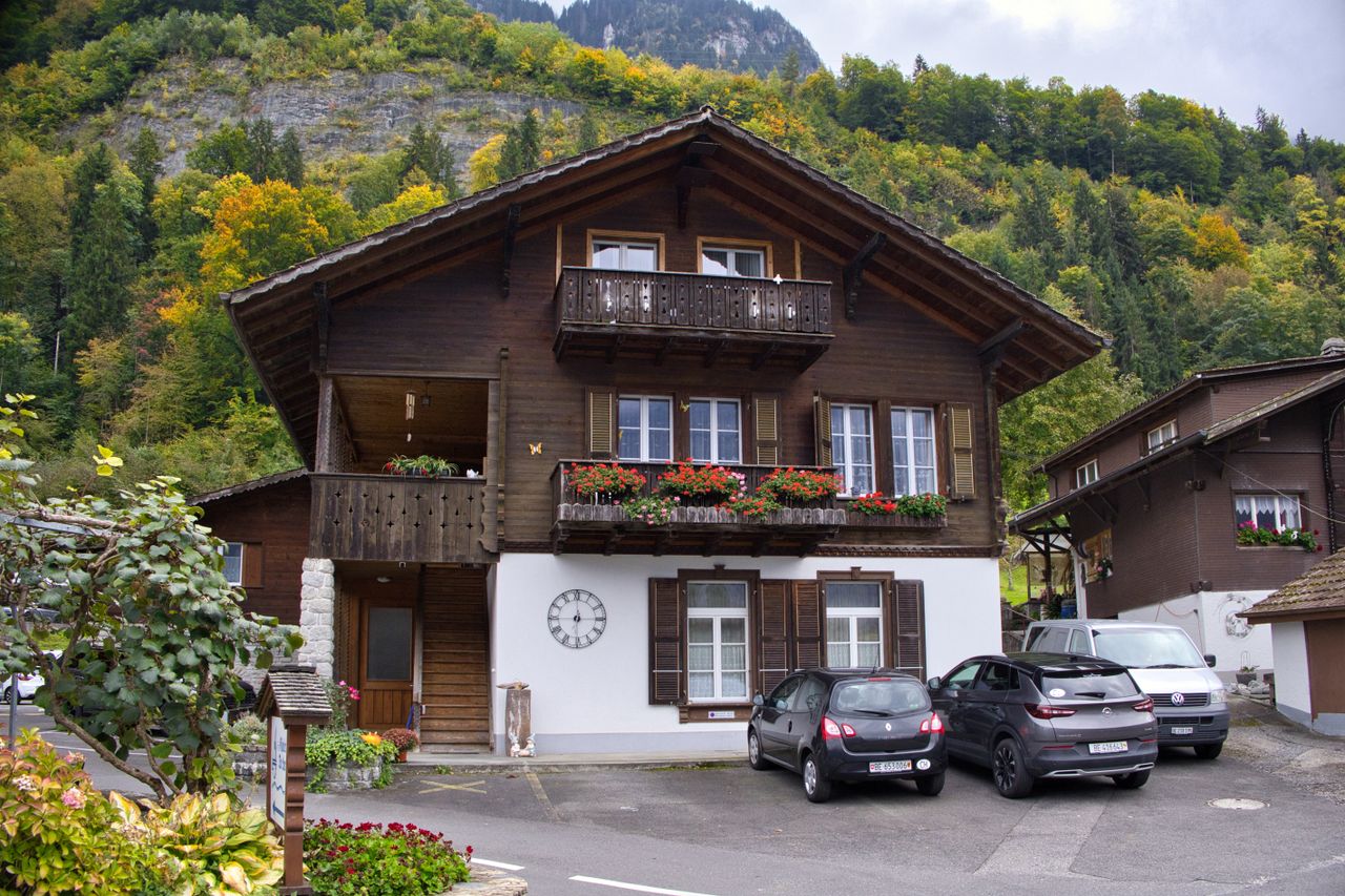 ours-journey Beautiful Swiss chalet amidst autumn foliage in alpine region.